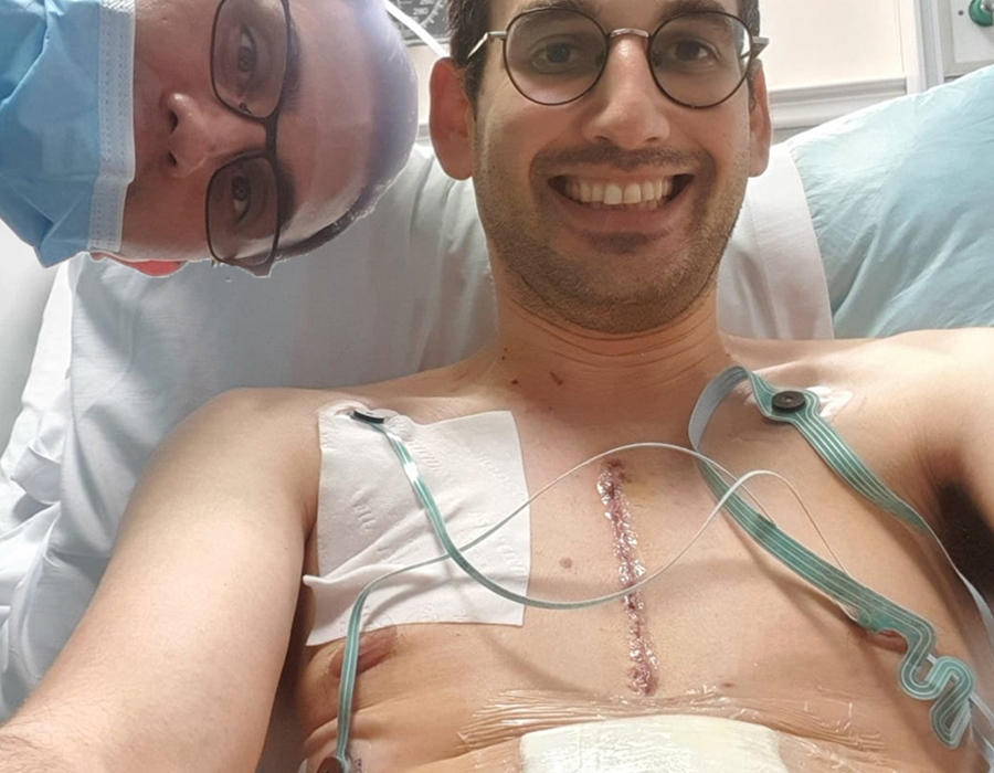 Shlomo recovering after surgery, smiling with chest scar visible